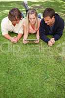 Three young people using a tactile tablet