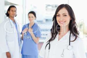 Young nurse standing in front of two colleagues