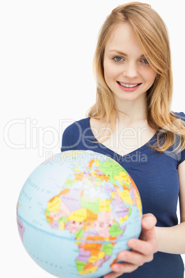 Woman holding a globe while looking at camera