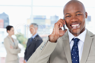 Young manager laughing while using his cell phone