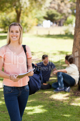 Portrait of a smiling female holding a textbook