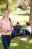 Portrait of a smiling female holding a textbook