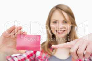Woman holding a loyalty card while showing it with a finger