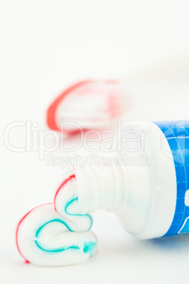 Blue tube of toothpaste next to a toothbrush