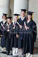 Happy graduates posing in single line