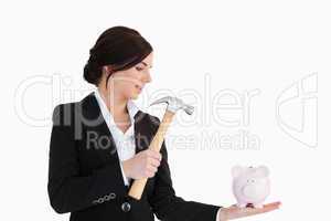 Businesswoman going to break a piggy-bank