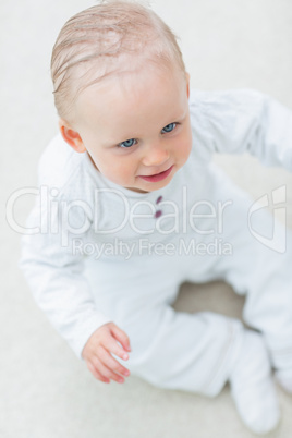 High view of a baby sitting on the floor