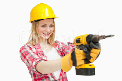 Joyful woman using an electric screwdriver