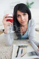 Woman with a magazine holding a glass of red wine