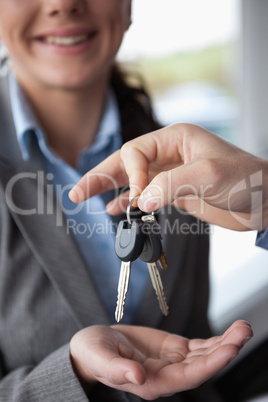 Hand holding keys over the hand of a woman