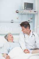 Doctor looking at a patient while taking her hand