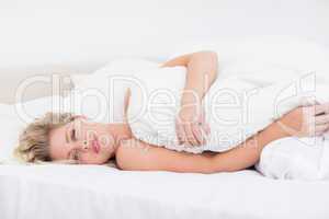 Young woman lying under a white duvet