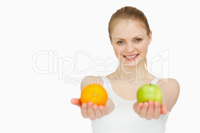 Young woman smiling while presenting fruits