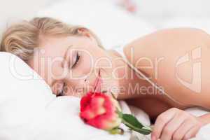 Smiling woman with a rose sleeping