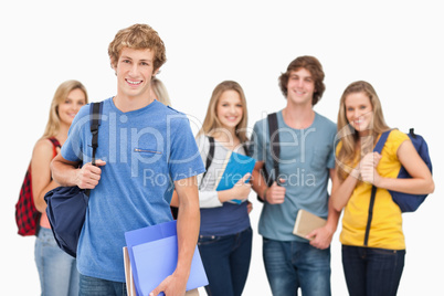 A group of smiling college students look into the camera as one