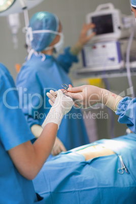 Nurse giving a surgical scissors to a doctor