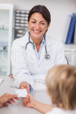 Smiling doctor giving a prescription to a patient