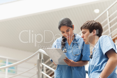 Nurse holding a clipboard while looking it