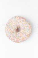 Extreme close up of a doughnut with multi coloured icing sugar