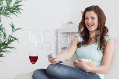 Woman smiling while pressing a remote control