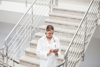 Doctor using a tablet computer on stairs