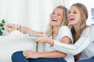 Sisters laughing at the tv together