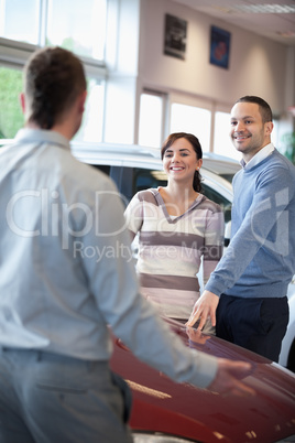 Couple smiling and chatting with a salesman