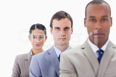 Big close-up of serious colleagues in a single line looking stra