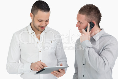 Two men calling and using a tablet computer