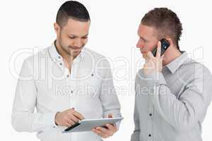Two men calling and using a tablet computer