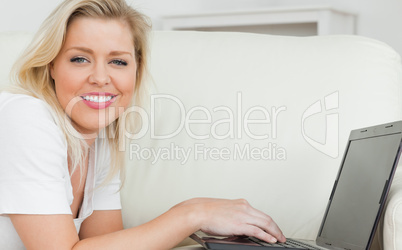 Woman smiling while using a laptop
