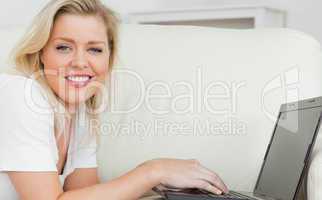 Woman smiling while using a laptop