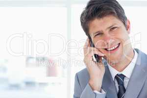 Young businessman laughing while talking on the phone