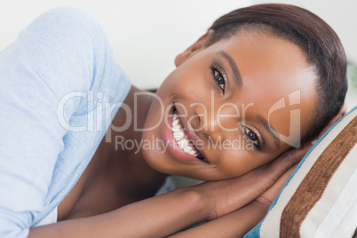 Black woman smiling while lying on side