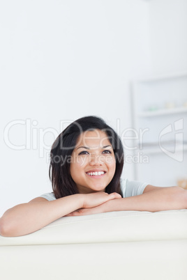 Smiling woman crossing her arms and resting her head on them