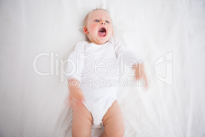 Little girl shouting while lying on a blanket