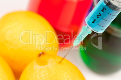 Syringe injecting liquid into a lemon