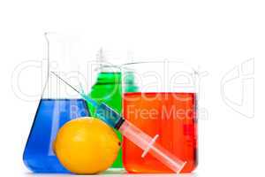 Syringe putting on an orange next to beakers