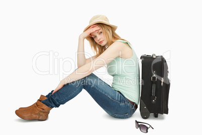 bored woman sitting near a suitcase
