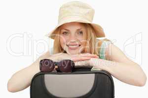 woman leaning on a suitcase while smiling