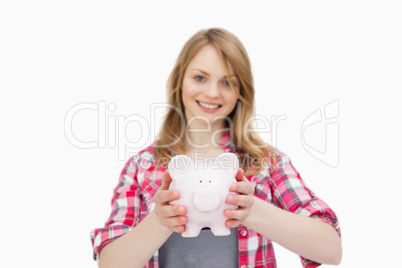 Woman holding a piggy bank while smiling