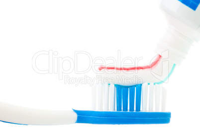 Close up of a tube of toothpaste with a toothbrush