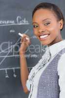 Teacher smiling while using a chalk