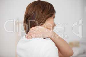 Brown-haired woman massaging her painful neck