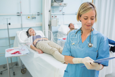 Nurse standing while looking at a clipboard