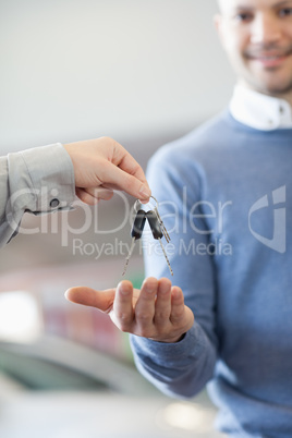 Customer receiving keys from a car dealer