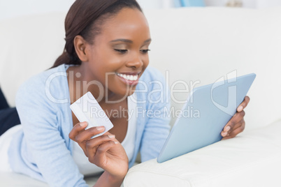 Black woman lying on front holding a credit card