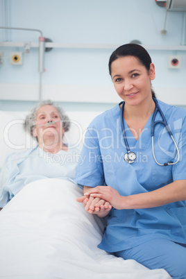 Nurse sitting on the bed next to a patient