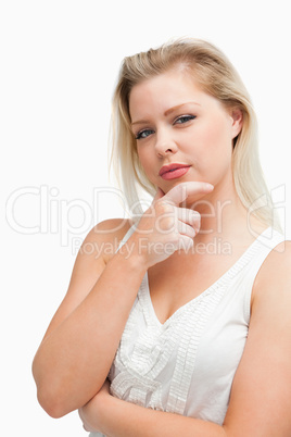 Thoughtful blonde woman placing her hand on her chin