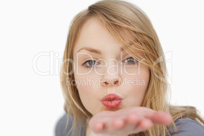 Blonde woman blowing on her palm